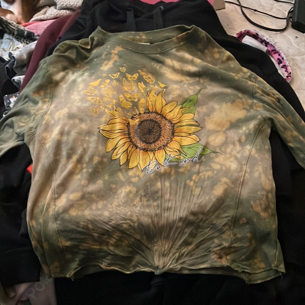 Sunflower shirt, long sleeve. Says “Be Kind.”